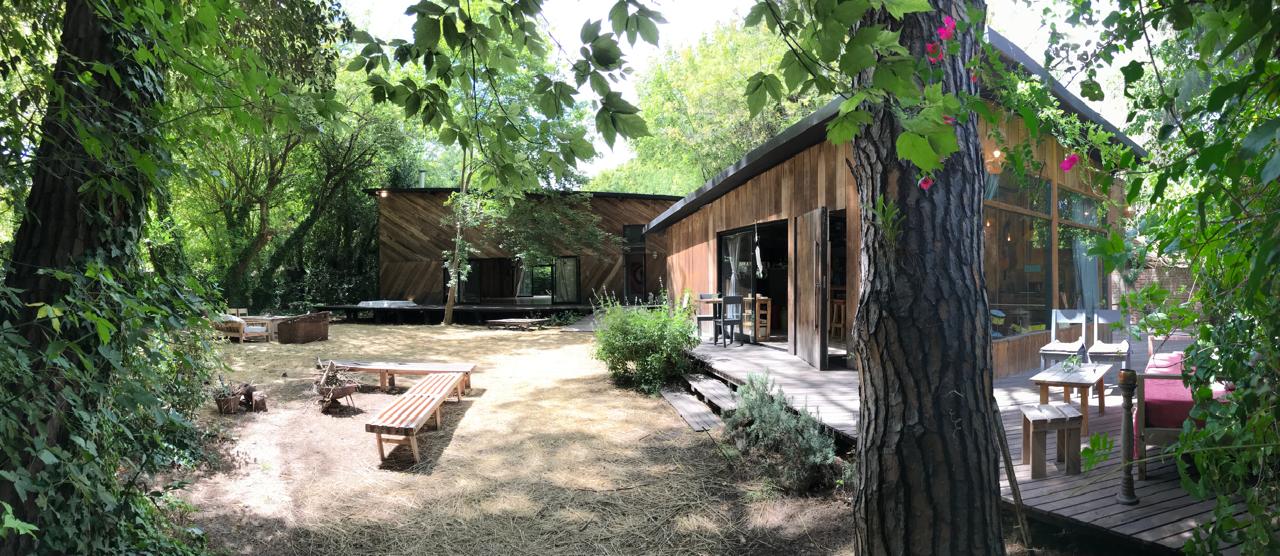 Vista del jardín y las construcciones de madera de Madre Tierra